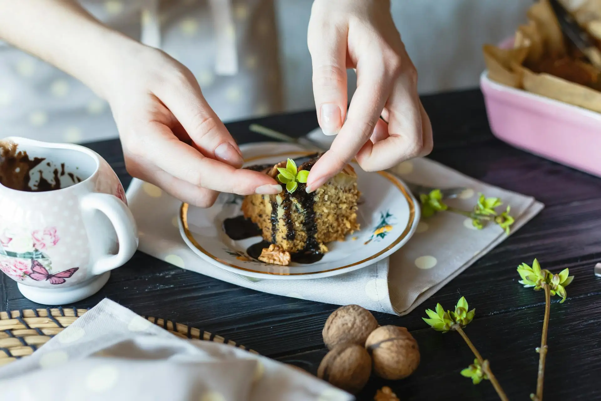 A chef carefully garnishing a dish with delicate herbs and edible flowers.