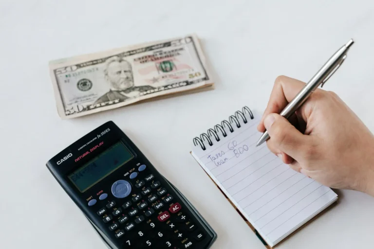 Image of a notebook with calculated budgeting figures and money, representing budget-friendly meal planning.