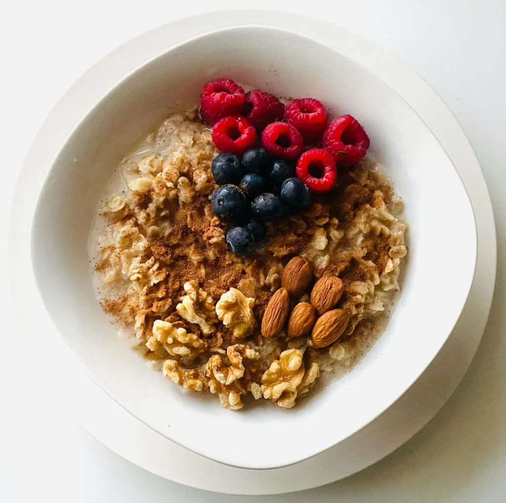 An assortment of energy-boosting foods, including bananas, nuts, and yogurt, displayed on a wooden table.