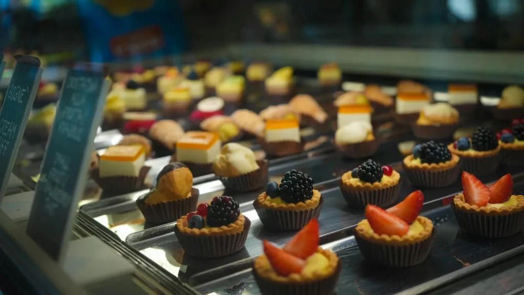 An assortment of French pastries including croissants, éclairs, and macarons on display in a bakery.