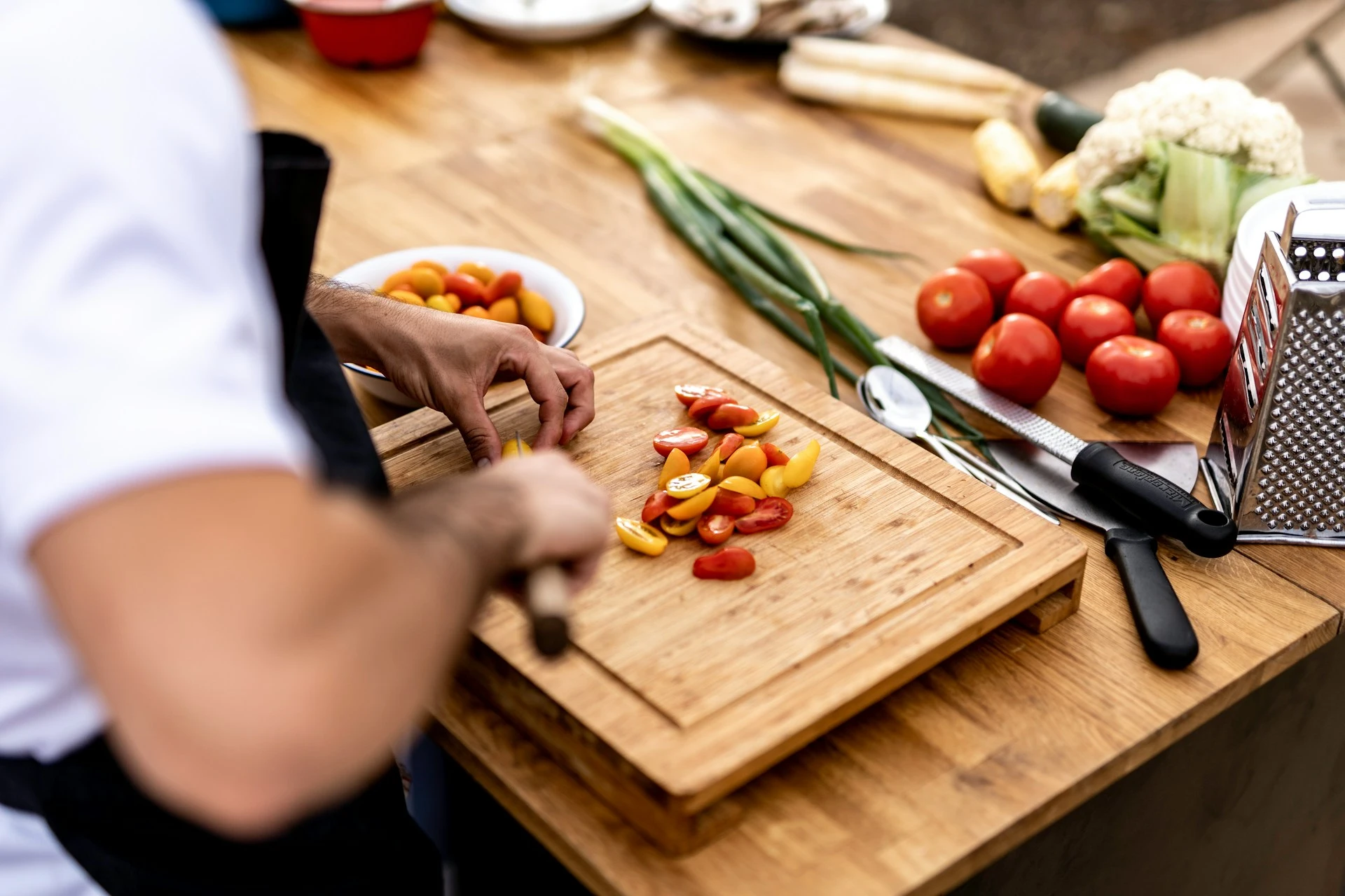 A cooking class with an instructor demonstrating traditional techniques to a group of participants in a kitchen.