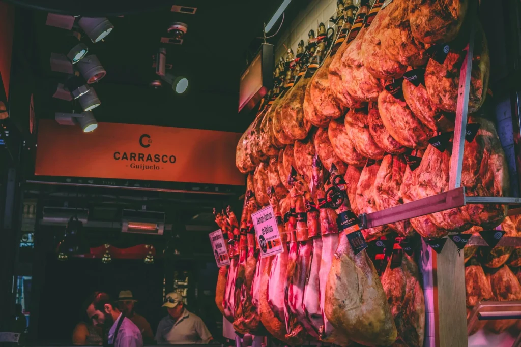 The vibrant Mercado de San Miguel filled with visitors browsing various food stalls.