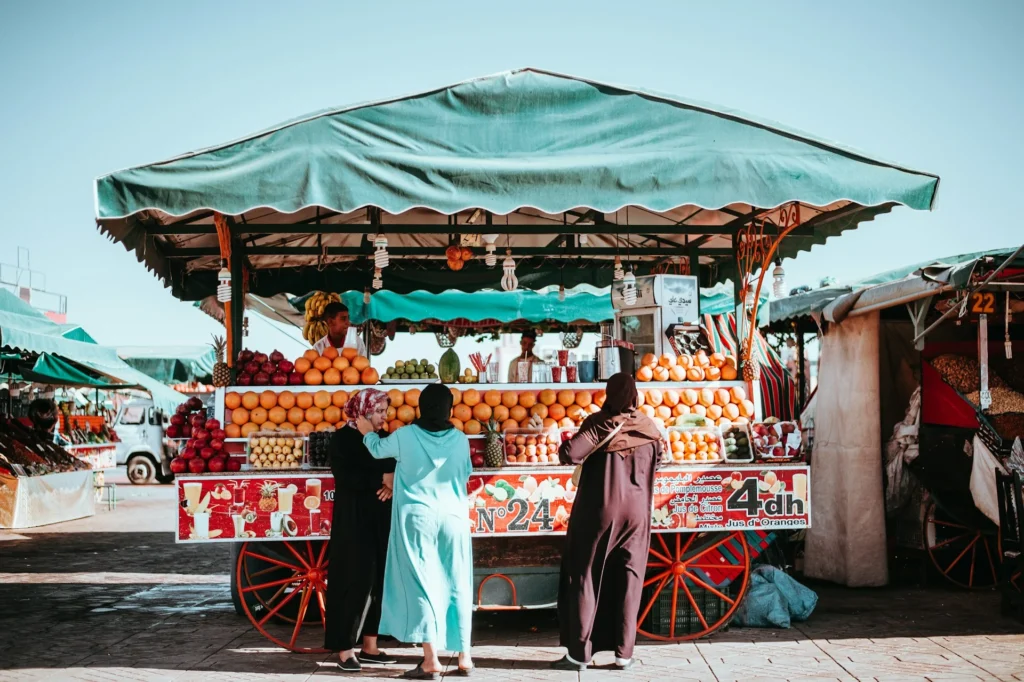 A vibrant street food market in Morocco with colorful stalls offering traditional Moroccan dishes.