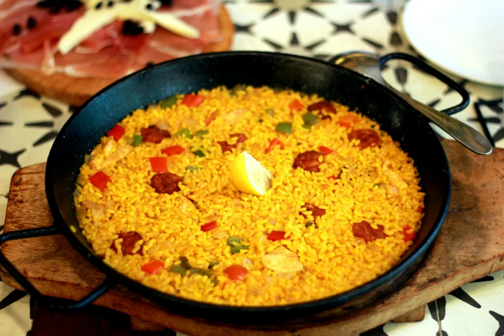 A large pan of traditional Spanish paella Dishes with saffron-infused rice, seafood, and vegetables.