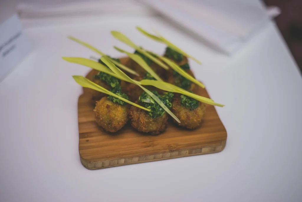 A traditional South African dish of boerewors with grilled vegetables and sauces on a plate.