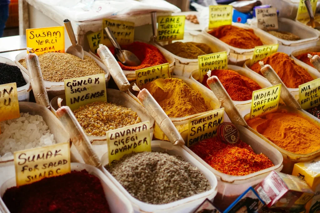 A colorful array of spices and herbs displayed in bins at a spice bazaar.