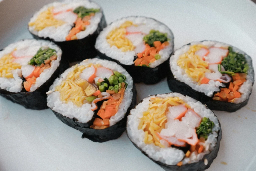 An assortment of sushi rolls and nigiri on a wooden sushi board, beautifully presented with soy sauce and wasabi.