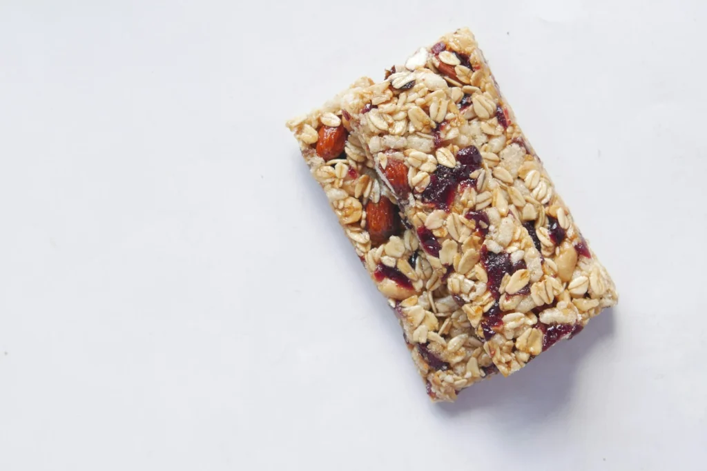 A variety of protein-rich snacks, including nuts, protein bars, and Greek yogurt, arranged on a table.