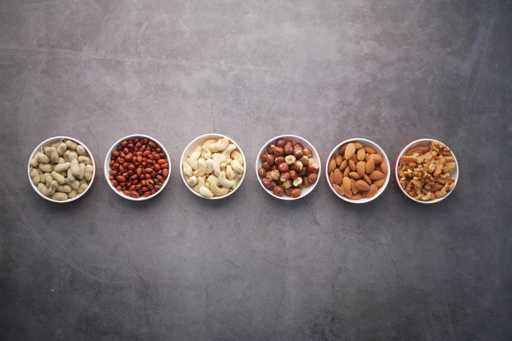 A collection of plant-based protein sources, including beans, lentils, tofu, and nuts, displayed on a kitchen table.