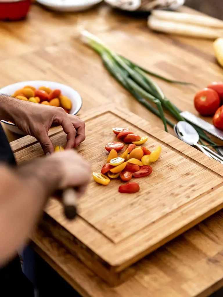 A cooking class with an instructor demonstrating traditional techniques to a group of participants in a kitchen.